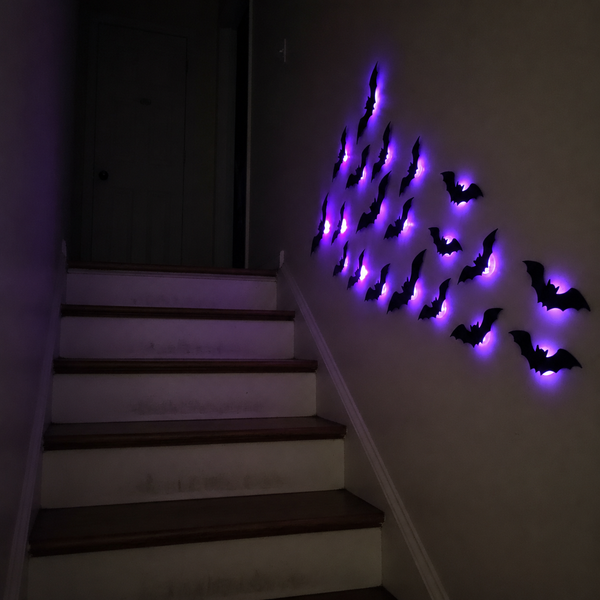 Purple Halloween bat lights beside a staircase